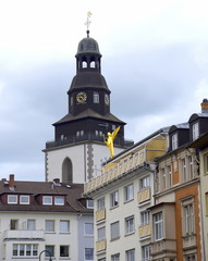 Hinter einer Häuserzeile emporragender Turm der Stadtkirche von Gießen