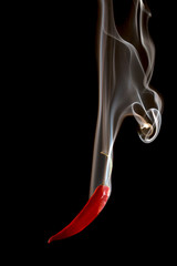 Obraz na płótnie Canvas Red pepper pouring smoke on black background