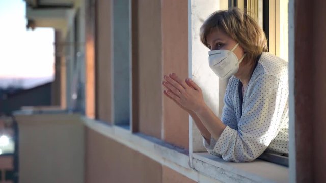 Coronavirus outbreak in London, fight against virus infection and support of those who sacrificing life to help infected patients. Woman in medical mask applauding health workers, supporting national