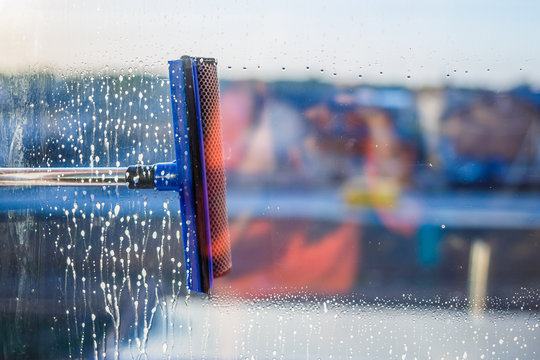 Window cleaning brush. Large window in a multi-storey building, cleaning service. Window cleaning in high-rise buildings, houses with a brush. Dust removal and glass washing.