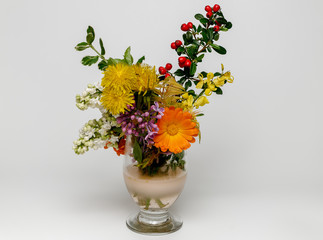 bouquet of colorful spring flowers in a vase on a bright background © K.Jagielski