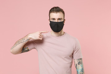 Young tattooed man guy in pastel casual t-shirt posing isolated on pink wall background studio...