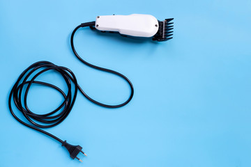 Electric hair clipper on blue background.