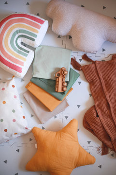 wooden car, blanket, pillow, rainbow, star. Flat lying, top view