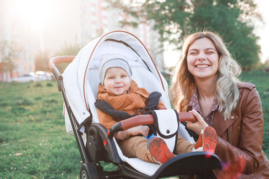 The image shows a mother standing with a pram and caring for a child