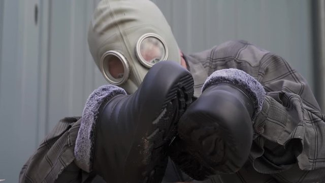 An elderly man in a gas mask. hands instead of feet. rubber shoes. freak. humpback. the average plan