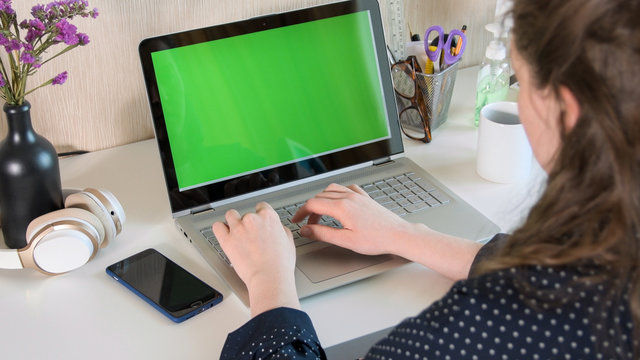 Woman working on laptop from home due to coronavirus self isolation. Authentic home workplace. Coronavirus outbreak 2020.