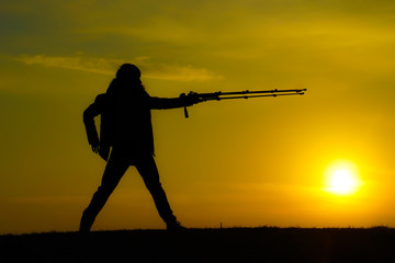 Fototapeta na wymiar 夕暮れの丘で戦う男性のイメージ