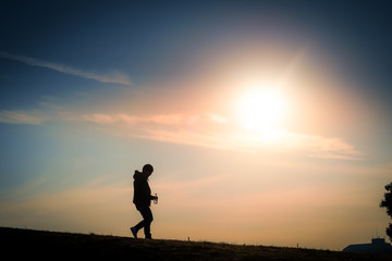 夕暮れの丘に立つ男性のシルエット
