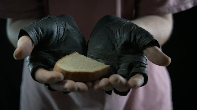 Alms to the beggar. A homeless person is given a piece of bread.