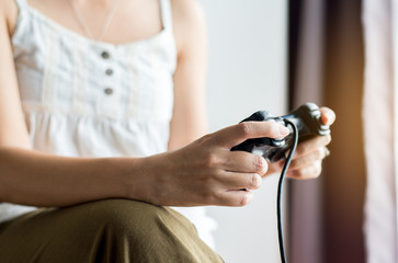 Close up of hands women playing video games at home,Female holding joystick