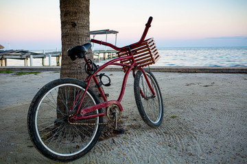 Red bike at the seashore with nobody ready to ride