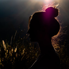 Silhouette of woman at sunset with the sun in the background