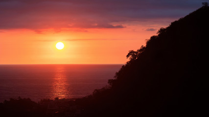 Sunset over the sea with mountain