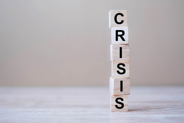 wooden cube blocks with CRISIS text on table background. Coronavirus pandemic, risk, fall Business, unemployment, Economic recession and Bankrupt concept