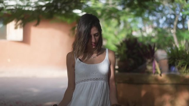 happy woman dancing outdoors and holding her white dress