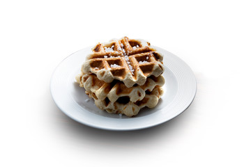 belgian waffle over a white plate with sugar