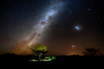 Fototapeta na wymiar Photographer and traveler take photo beautiful starry night at alone tree in Namibia. Night landscape milky way photograph. 