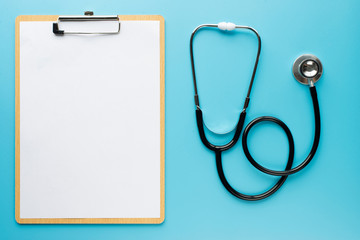 Stethoscope with clipboard on blue background
