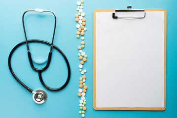 Stethoscope with clipboard on blue background copy space for text.