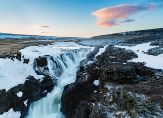 Fototapeta premium Canyon Waterfall in Iceland at dawn with pink clouds overhead
