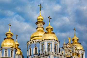 Fototapeta na wymiar Clouds surround St Michaels in Kiev classic golden cupolas of the cathedral.