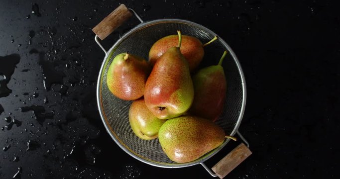 Fresh pears in a colander slowly rotate.