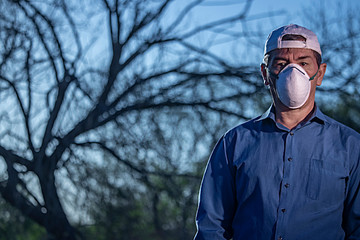 Middle-aged man dressed in blue shirt puzzled by coronavirus situation in parke looking thoughtful