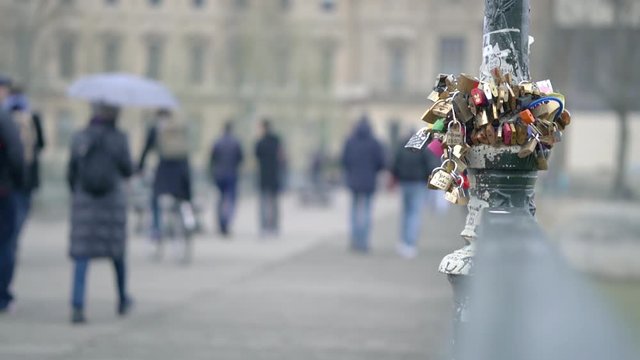 Slow motion clip of love locks on a pole in paris city centre with people walking out of focus blur in the background