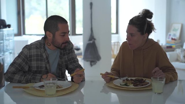 Medium shot of young couple eating togehter at home
