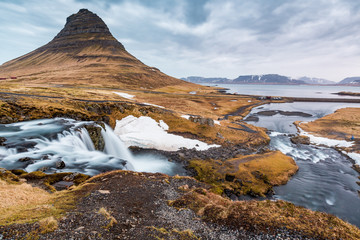 Kirkjufell mountain hoveers over breathtaking waterfalls
