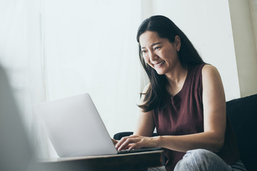 using computer.hand typing keyboard laptop online chatting search form internet while working sitting on sofa.concept for work from home.technology device contact communication business people