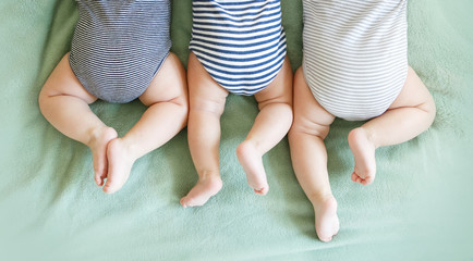 Newborn triplets lie on a stomach on a blanket - 346350586