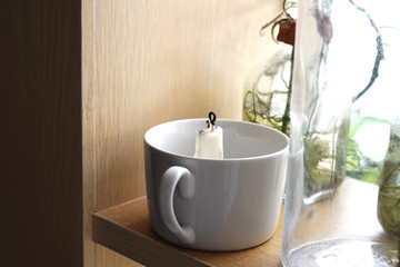 Small dead candle inside tea cup