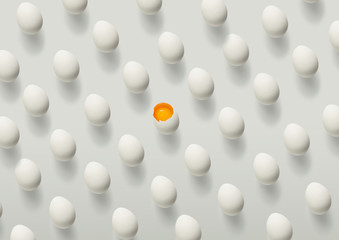Pattern of white eggs on a white table, one egg with a yolk in the center. Minimal concept
