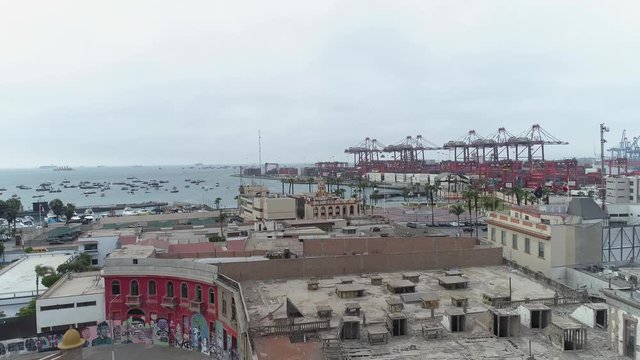 Drone flight where at the beggining you can see on the left a classic fortress called Real Felipe and on the right old homes from the 1920's revealing the pacific ocean and a container port.