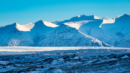 Wind swept snow covered mountain peaks near Jokulsarlon Glacier lagoon