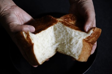 食パンをちぎる手と食パンです