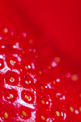 Blurred natural red background. Strawberry background. Strawberry berries texture. Beautiful abstract natural red backdrop. Vertical, close-up, nobody, cropped shot. Healthy eating concept.