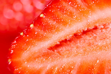 Strawberry background. Blurred natural red background. Texture of strawberry berries. Beautiful sliced strawberries close-up. Horizontal, close-up, nobody. Healthy eating concept.