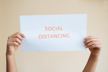 Hands holding a sign with message about social distancing. Social distancing, keep distance in public society people to protect.