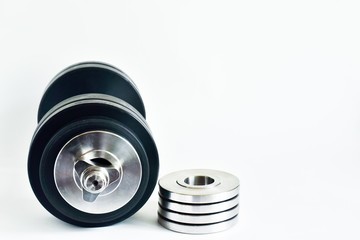 metal dumbbell and weight wheels on a white background, front view. Sports at home. place for text.