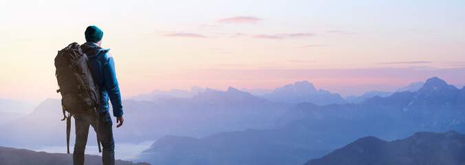 Wanderer bei Sonnenaufgang auf einem Berggipfel