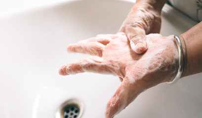 Fototapeta premium Asian elderly woman washing hand with foam soap.