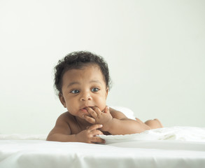 African newborn baby boy lying in bed in the morning.Happy,excited,smile and enjoy emotion.He have beautiful eyes.