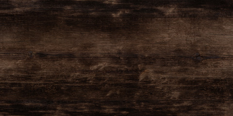 Texture of black and dark brown old wood. Charred and burnt old Board with knots. Wide burned board texture close-up, panoramic banner.