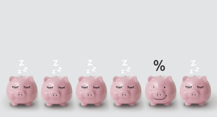 Piggy bank with percents in column next to banks depicting sleeping