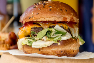 Fresh melting burger ready to eat during fast food festival. Outdoor catering event, brunch