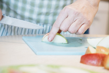 Obraz na płótnie Canvas A person cutting a piece of apple on a table