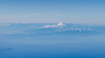 Fuji mountain from above in far distance with blue theme blue sky and cloud